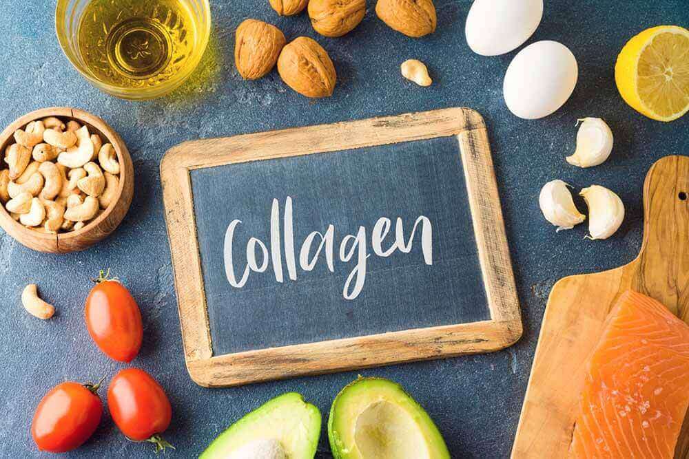 Слово COLLAGEN латиницею, написане крейдою на дошці для малювання в оточенні різноманітних продуктів харчування